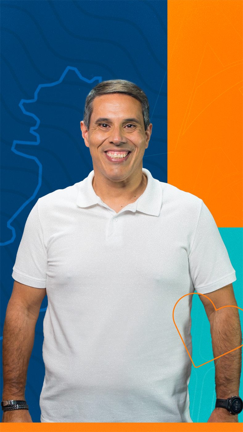 Amaro Neto sorrindo, com a arte da campanha ao fundo